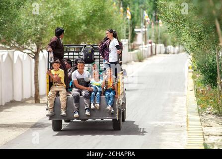 Thiksay Kloster in Thiksey Dorf, Indien – 20. August 2016: Smilling locals tibetische Familie fährt am LKW vorbei und schaut in die Kamera in Thiksey Dorf Stockfoto