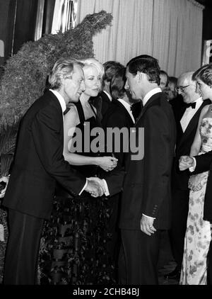 Der Prinz von Wales trifft den australischen Schauspieler Paul Hogan, 49, Star von 'Crocodile' Dundee II, der heute Abend im Empire, Leicester Square, London, Premiere feiert. Neben Hogan ist seine Co-Star Linda Kozlowski. Stockfoto