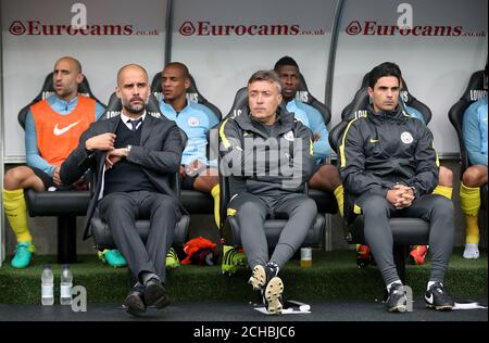 (Von links nach rechts) Manchester City Manager Pep Guardiola, Manchester City Assistant Coach Domenec Torrent und Coach Mikel Arteta auf der Bank Stockfoto