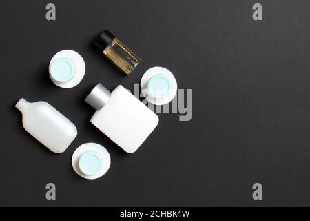 Draufsicht Zusammensetzung von kleinen Reiseflaschen und Gläsern für Kosmetikprodukte auf farbigem Hintergrund. Gesichtshautpflege-Konzept mit Kopieplatz für yo Stockfoto