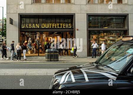 London - September 2020: Shopper, die am Urban Outfitters Store in der Oxford Street im Westen vorbeilaufen Stockfoto