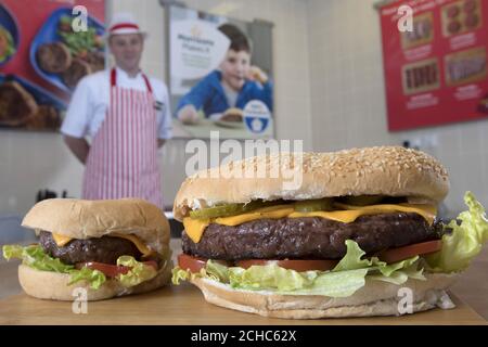 Der Metzger Shaun Speight bereitet den „Vater aller Burger“ zu, der mit einem vollen Pfund 100 % britischem Rindfleisch in Morrisons in Harrogate, West Yorkshire, hergestellt wird und der im Vorfeld des Vatertages für £3 in den Supermärkten landesweit erhältlich sein wird. Stockfoto