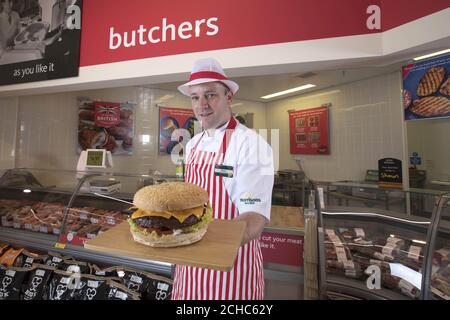 Der Metzger Shaun Speight bereitet den „Vater aller Burger“ zu, der mit einem vollen Pfund 100 % britischem Rindfleisch in Morrisons in Harrogate, West Yorkshire, hergestellt wird und der im Vorfeld des Vatertages für £3 in den Supermärkten landesweit erhältlich sein wird. Stockfoto