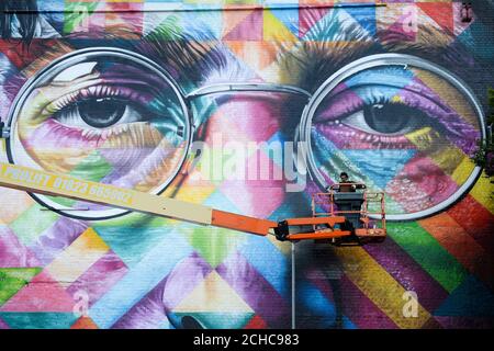 Ein Graffiti-Künstler arbeitet an einem riesigen Wandgemälde von John Lennon, während er am Upfest, einem Street Art und Graffiti Festival in Bristol, teilnimmt. Stockfoto