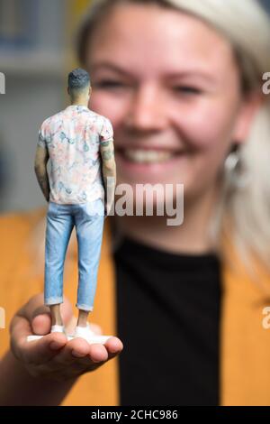 Ella Gradwell, 22 Jahre alt aus Stratford-upon-Avon, inspiziert eine von sieben 3D-gedruckten Figuren von alleinstehenden Männern, die von der Online-Dating-Website Match für ein Pop-up-Fenster „Model Men“ in London erstellt wurden und für alleinstehende Frauen bereit sind, die echten Singles über einen Link auf der Verpackung zu durchsuchen und zu kontaktieren. Stockfoto