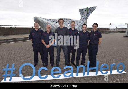 REDAKTIONELLE VERWENDUNG NUR der zweifache olympische Goldmedaillengewinner James Cracknell (3. Links) mit Penarth Division des South Wales Fire Service, als sie gemeinsam mit Sky Ocean Rescue einen 10 Meter langen Wal in Cardiff Bay, Wales enthüllen, Die vollständig aus recyceltem Kunststoff aus dem Meer, Strand reinigt und lokale Recycling-Pflanzen hergestellt, um das Bewusstsein für das Thema der Meeresgesundheit zu erhöhen. Stockfoto