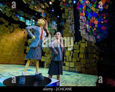 Die Schauspielerin Emma Moore, die Matilda in der Matilda The Musical Stage-Show der Royal Shakespeare Company im Cambridge Theatre spielt, steht mit einem einzigartigen LEGO-Backstein aus der Figur „Matilda“, um den Roald Dahl Day zu feiern, der den Geburtstag des Geschichtenerzählers am 13. September in London feiert. Stockfoto