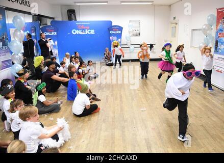 REDAKTIONELLE VERWENDUNG NUR Ashley Banjo (Sitting Left Center) veranstaltet einen Tanzworkshop mit Kindern der Chisenhale Primary School als Teil des Fit to Dance Programms, bevor Disney on Ice diesen Herbst nach Großbritannien kommt. DRÜCKEN SIE ZUORDNUNG. Bilddatum: Mittwoch 13 2017. September. Disney on Ice präsentiert ÔPassport to AdventureÕ mit dem König der Löwen, der kleinen Meerjungfrau, Frozen und Peter Pan. Jede Show beginnt mit einer Fit to Dance Pre-Show, die das Publikum dazu einlädt, sich mit Zootropolis Charakteren aufzuwärmen, bevor das Skaten beginnt. Die Show wird vom 22. September bis 30. Dezember durch Großbritannien Touren Stockfoto