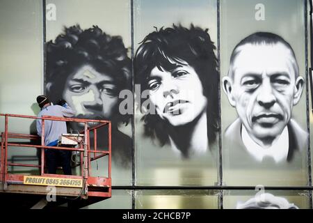 Bristol Künstler 'Voyder' arbeitet an einem Wandbild Portrait von (von links nach rechts) Jimi Hendrix, Mick Jagger und Sergei Rachmaninow auf der Vorderseite der Colston Hall, Bristol, feiern Künstler, die gespielt haben an der Musik auf ihr 150-jähriges Bestehen. Stockfoto