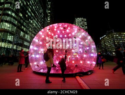 Mitglieder der Öffentlichkeit sehen Sonic Bubble von Eness beim jährlichen Canary Wharf Winter Lights Festival 2018 in London. Stockfoto