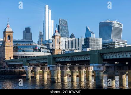 Blick auf die Stadt von Southwark nach Nordosten an einem strahlend blauen Himmel. Cannon Street Eisenbahnbrücke schneidet den Rahmen. Von links nach rechts, Türme o Stockfoto