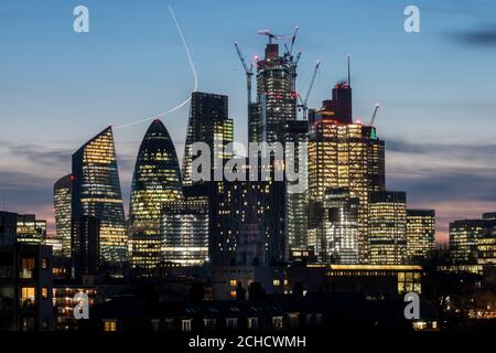 Blick nach Südwesten zur Stadt in der Dämmerung. Der leichte Weg von einem Flugzeug führt über den östlichen Cluster. Von links, Walkie-Talkie teilweise Stockfoto