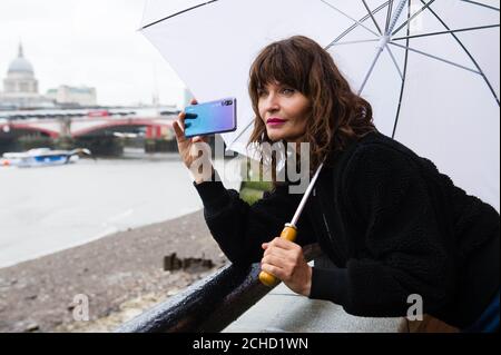 REDAKTIONELLE VERWENDUNG NUR Helena Christensen wird von Wettbewerbssiegern bei einer Huawei P20 Pro Fotografie-Meisterklasse in der OXO Tower Brasserie in London fotografiert. Stockfoto