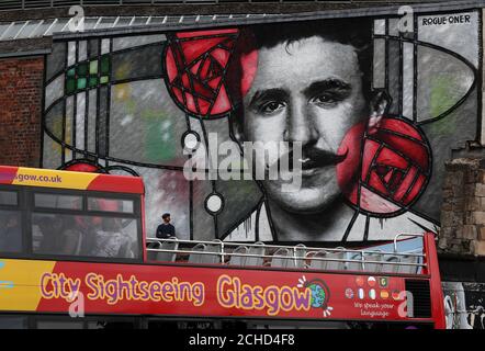 Künstler Bobby McNamara als Rogue bekannt - ein Blick auf seine Arbeit bei seiner Enthüllung als Glasgow tour bus übergibt die riesigen street art Wandbild zu Charles Rennie Mackintosh gewidmet auf eine große Wand mit Blick auf den Clutha bar in Glasgow gemalt. Stockfoto