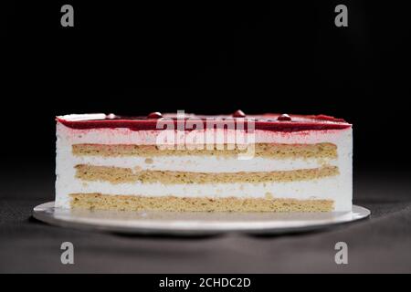 Halb oder Scheibe weiße Schokolade Mousse und Erdbeeren Kuchen isoliert auf schwarzem Hintergrund. Speicherplatz kopieren. Hochwertige Fotos. Stockfoto