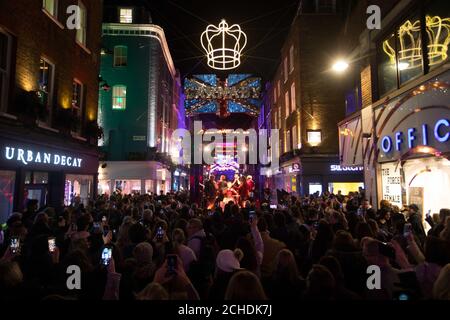 REDAKTIONELLE VERWENDUNG NUR Bulsara und seine Queenies, Offizielle Queen Tribute Band treten auf der Bühne unter den Bohemian Rhapsody Lichter als Weihnachten startet in der Carnaby Street, London. Stockfoto