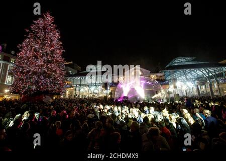 REDAKTIONELLE VERWENDUNG NUR Menschenmengen versammeln sich, um die Weihnachtsbeleuchtung von Covent Garden auf der Piazza zu sehen. Stockfoto