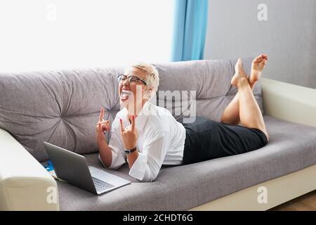 Glückliche kaukasische Lehrerin Frau schreien durch Glück, sie hat keine Lektionen. Zu Hause auf dem Sofa Stockfoto