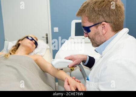 Frau mit Laser-Behandlung am Arm Stockfoto