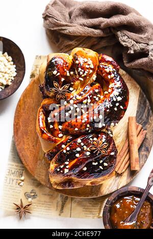 Babka oder Brioche Brot mit Aprikosenmarmelade und Nüssen. Hausgemachtes Gebäck zum Frühstück. Konkreter Hintergrund. Stockfoto