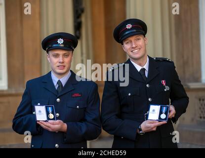 Feuerwehrmann Ricky Davis (links) und Kommandant Daniel Cooper mit ihrer Queen's Gallantry Medal, die nach einer Investiturzeremonie im Buckingham Palace, London, für die Rettung von Bewohnern in einem Pfleheim während eines schweren Feuers verliehen wurde. Stockfoto