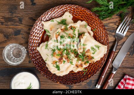 Pierogi mit gebratenen Zwiebeln und gehacktem Dill. Gesunde gedünstete Knödel gefüllt mit Kartoffeln. Polnische, ukrainische Küche Essen. Varenniki Stockfoto