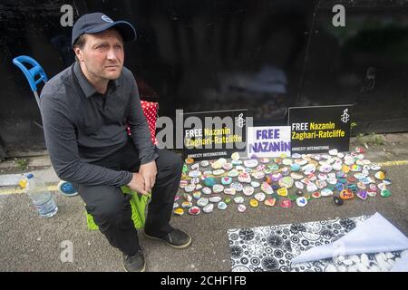 Richard Ratcliffe, der Ehemann des inhaftierten Nazanin Zaghari Ratcliffe, sitzt neben bemalten Steinen, die Unterstützung vor der iranischen Botschaft in Knightsbridge, London versprechen, als sein Hungerstreik in seinen achten Tag geht. Der Protest von Herrn Ratcliffe begann am Samstag, dem 15. Juni, zur gleichen Zeit, als seine Frau im Iran in Hungerstreik trat, wo sie seit April 2016 im Gefängnis sitzt. Stockfoto