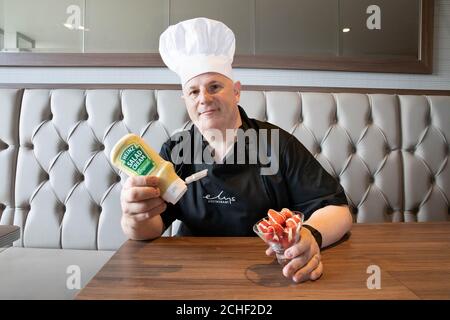 NUR FÜR REDAKTIONELLE VERWENDUNG Chefkoch Bernado Garea im unabhängigen Wimbledon-Kaufhaus Elys gibt seinem Gericht, Erdbeeren und Heinz Salad Cream, den letzten Schliff, eine Variante eines britischen Klassikers, der zum Beginn der Tennissaison in Wimbledon kreiert wurde. Stockfoto