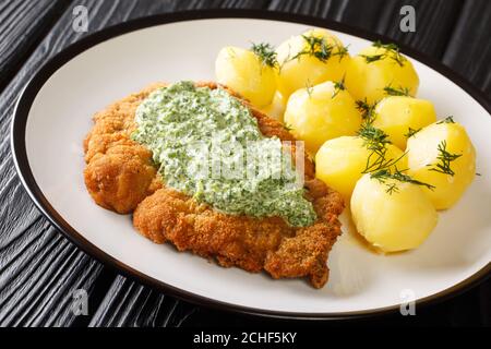 Köstliche deutsche Küche Schnitzel mit gekochten neuen Kartoffeln und die berühmte Frankfurter grüne Sauce close-up in einem Teller auf dem Tisch. Horizontal Stockfoto