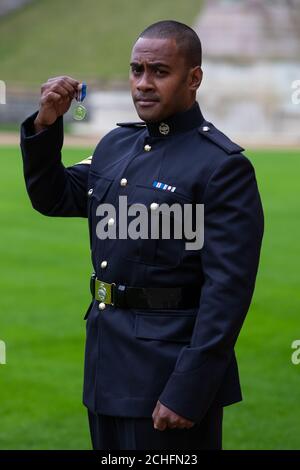 Korporal Saimone Qasenivalu, Royal Tank Regiment, mit seiner Queen's Gallantry Medal, verliehen von Queen Elizabeth II bei einer Investiturzeremonie in Windsor Castle, Berkshire. Stockfoto