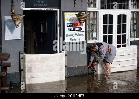 Ein Mitarbeiter der Vue Bar in Worcester installiert Hochwasserschutz, wie das Vereinigte Königreich hat sich durch die weit verbreitete überschwemmung geschlagen worden, nachdem Flüsse über die Ufer burst nach dem Wochenende???s Heavy Rain. Stockfoto