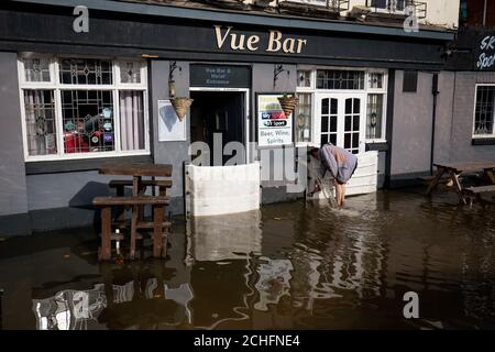 Ein Mitarbeiter der Vue Bar in Worcester installiert Hochwasserschutz, wie das Vereinigte Königreich hat sich durch die weit verbreitete überschwemmung geschlagen worden, nachdem Flüsse über die Ufer burst nach dem Wochenende???s Heavy Rain. Stockfoto