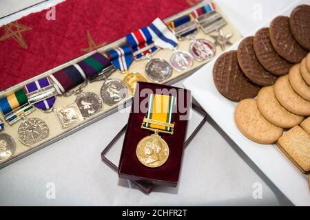 REDAKTIONELLE VERWENDUNG NUR die D-Day Darlings treten auf einer Teeparty auf, die von SainsburyÕs für die Armeegemeinschaft in Preston veranstaltet wird, um Gelder für den diesjährigen Poppy Appeal zu sammeln. PA-Foto. Bilddatum: Freitag, 8. November 2019. Ray Herrington, 80 Jahre alt, erhält von Store Manager Mark Fitzgerald einen Gedenkstrauß und wird ihm von seinem Sohn Mark Herrington gewidmet, um seinen Dienst bei The Queen's Flight zu würdigen. In diesem Jahr feiert Sainsbury's sein 25. Jahr der Partnerschaft mit der Royal British Legion's Poppy Appeal. Bildnachweis sollte lauten: Dave Thompson/PA Wire Stockfoto