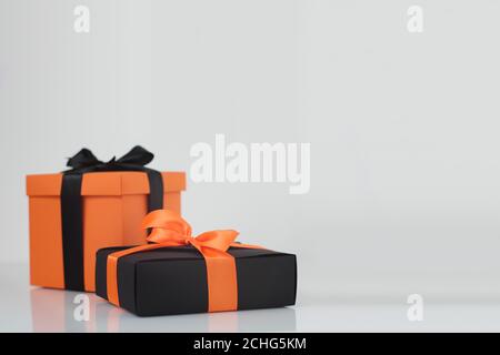 Dekoriert schwarz und orange Farbe halloween Geschenkboxen auf grauem Hintergrund mit Kopieplatz für Text, Ecke Komposition Stockfoto
