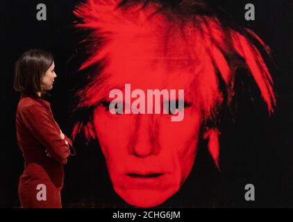 A Tate Modern Gallery Assistant blickt auf 'Self Portrait', 1986, auf eine Presseansicht der großen neuen Andy Warhol Ausstellung in der Tate Modern, London, die klassische Pop-Art-Stücke und Werke zeigt, die noch nie in Großbritannien gezeigt wurden. PA-Foto. Bilddatum: Dienstag, 10. März 2020. Bildnachweis sollte lauten: Dominic Lipinski/PA Wire Stockfoto