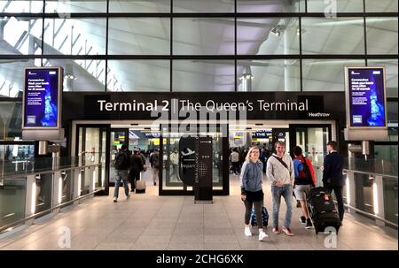 Warnungen der Regierung vor dem Coronavirus am Eingang zum Terminal 2 des Londoner Flughafens Heathrow am Tag nachdem der Premierminister sagte, dass Covid-19 "die schlimmste öffentliche Gesundheitskrise seit einer Generation ist", und der Spitzenwissenschaftler der Regierung warnte davor, dass bis zu 10,000 Menschen in Großbritannien bereits infiziert sind. Stockfoto