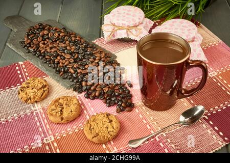 Schokoladenkekse mit Schiefertisch mit Mischung aus natürlichem und geröstetem Kaffee, mit Gläsern Honig, Tasse Kaffee, Löffel, Zucker auf Holztisch schmücken Stockfoto