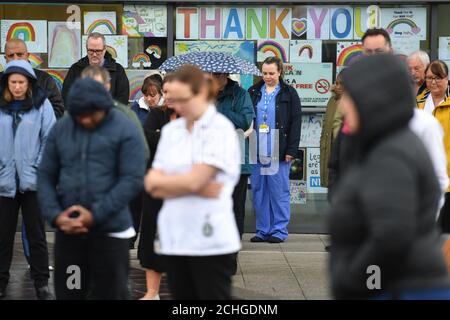 Die Mitarbeiter stehen vor dem Royal Derby Hospital, während einer Schweigeminute, um dem NHS-Personal und den Schlüsselarbeitern, die während des Coronavirus-Ausbruchs gestorben sind, Tribut zu zollen. Stockfoto