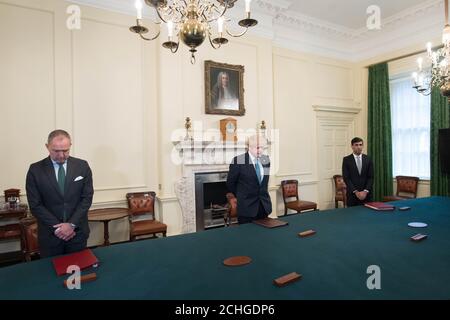 (Von links nach rechts ) Kabinettsminister Mark Sedwill, Premierminister Boris Johnson und Schatzkanzler Rishi Sunak, stehen in der Downing Street 10, London, um ein Schweigeminute zu beobachten, in dem die NHS-Mitarbeiter und Schlüsselarbeiter zu Ehren des während des Coronavirus-Ausbruchs verstorbenen Personals gezollt werden. Stockfoto