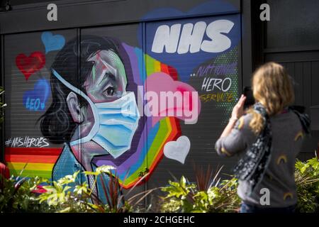 Eine Frau fotografiert Graffiti zur Unterstützung des NHS im Südosten Londons, während Großbritannien weiterhin in der Blockierung ist, um die Ausbreitung des Coronavirus einzudämmen. Stockfoto