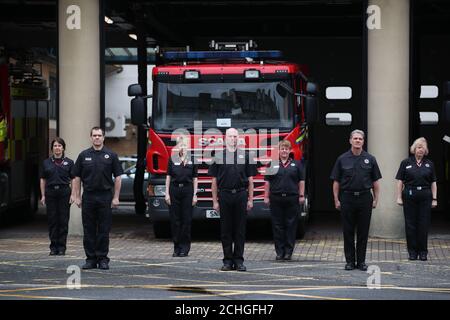 Grüne Uhr und Bahnhofsmitarbeiter an der Tollcross Community Fire Station in Edinburgh beobachten eine Schweigeminute , in Erinnerung an ihre Kollegen, die am Feuerwehrgedenkenstag ihr Leben verloren haben. Stockfoto