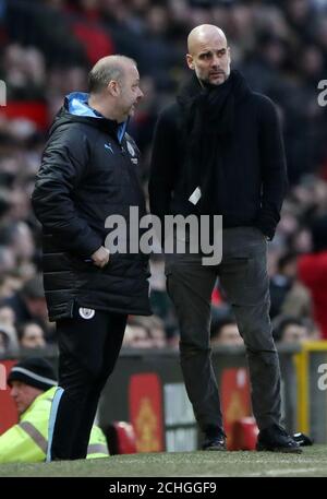 Manchester City Manager Pep Guardiola hört Manchester Citys 1. Teamassistent Coach Rodolfo Borrell (links) während des Premier League Spiels in Old Trafford, Manchester. Stockfoto