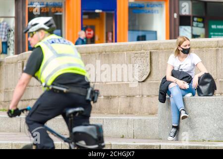 Ein Polizist ist auf der High Street aus dem Stadtzentrum von Paisley, die einschließlich anderer Städte in Renfrewshire, hat zusätzliche Lockdown Maßnahmen gegen Mitternacht letzte Nacht hinzugefügt entdeckt. Aufgrund eines Spikes in Covid-19 Fällen. Kredit: Euan Cherry Stockfoto