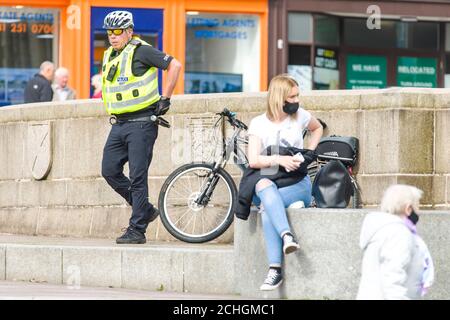 Ein Polizist ist auf der High Street aus dem Stadtzentrum von Paisley, die einschließlich anderer Städte in Renfrewshire, hat zusätzliche Lockdown Maßnahmen gegen Mitternacht letzte Nacht hinzugefügt entdeckt. Aufgrund eines Spikes in Covid-19 Fällen. Kredit: Euan Cherry Stockfoto