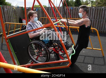 Am 0001. Juni 22 ist Gregor Marshall mit seiner Mutter Karen als Gregor auf der Rollstuhlschaukel im aussen Therapiebereich des Craighalbert Centers unterwegs. Coronavirus-Adaptionen wurden im Scottish Centre for Children with Motor Impairments, Craighalbert Centre, Cumbernauld, installiert, da Schottland die Maßnahmen zur Blockierung des Coronavirus schrittweise aufhebt. Stockfoto