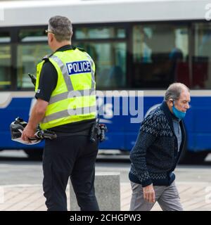 Ein Polizist ist auf der High Street aus dem Stadtzentrum von Paisley, die einschließlich anderer Städte in Renfrewshire, hat zusätzliche Lockdown Maßnahmen gegen Mitternacht letzte Nacht hinzugefügt entdeckt. Aufgrund eines Spikes in Covid-19 Fällen. Kredit: Euan Cherry Stockfoto