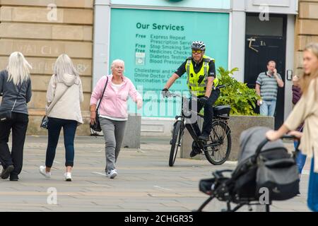 Ein Polizist ist auf der High Street aus dem Stadtzentrum von Paisley, die einschließlich anderer Städte in Renfrewshire, hat zusätzliche Lockdown Maßnahmen gegen Mitternacht letzte Nacht hinzugefügt entdeckt. Aufgrund eines Spikes in Covid-19 Fällen. Kredit: Euan Cherry Stockfoto