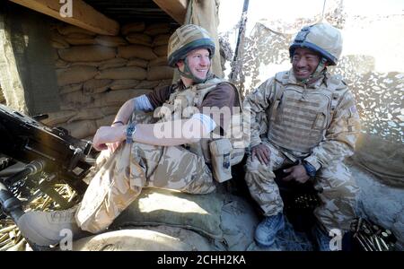 Prinz Harry plaudert mit einem Gurkha-Soldaten, nachdem er ein 50-mm-Maschinengewehr auf Taliban-Kämpfer abgefeuert hatte, während er in der Provinz Helmand in Südafghanistan stationiert war. Stockfoto