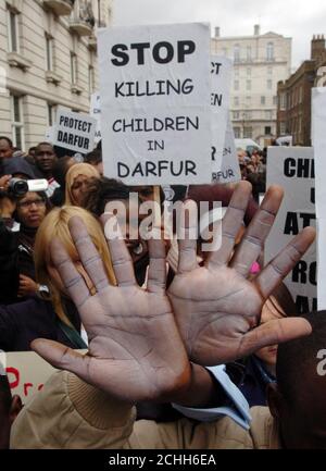 Demonstranten heben ihre bemalten Hände, während sie sich vor der sudanesischen Botschaft in London zu einer Kundgebung versammeln, die das Ende der Krise in Darfur fordert. Stockfoto