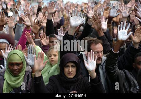 Demonstranten heben ihre bemalten Hände, während sie sich vor der sudanesischen Botschaft in London zu einer Kundgebung versammeln, die das Ende der Krise in Darfur fordert. Stockfoto